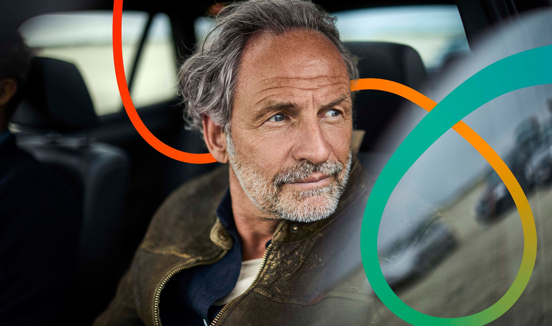 Friendly-looking man sits in his car looking happily out of the window