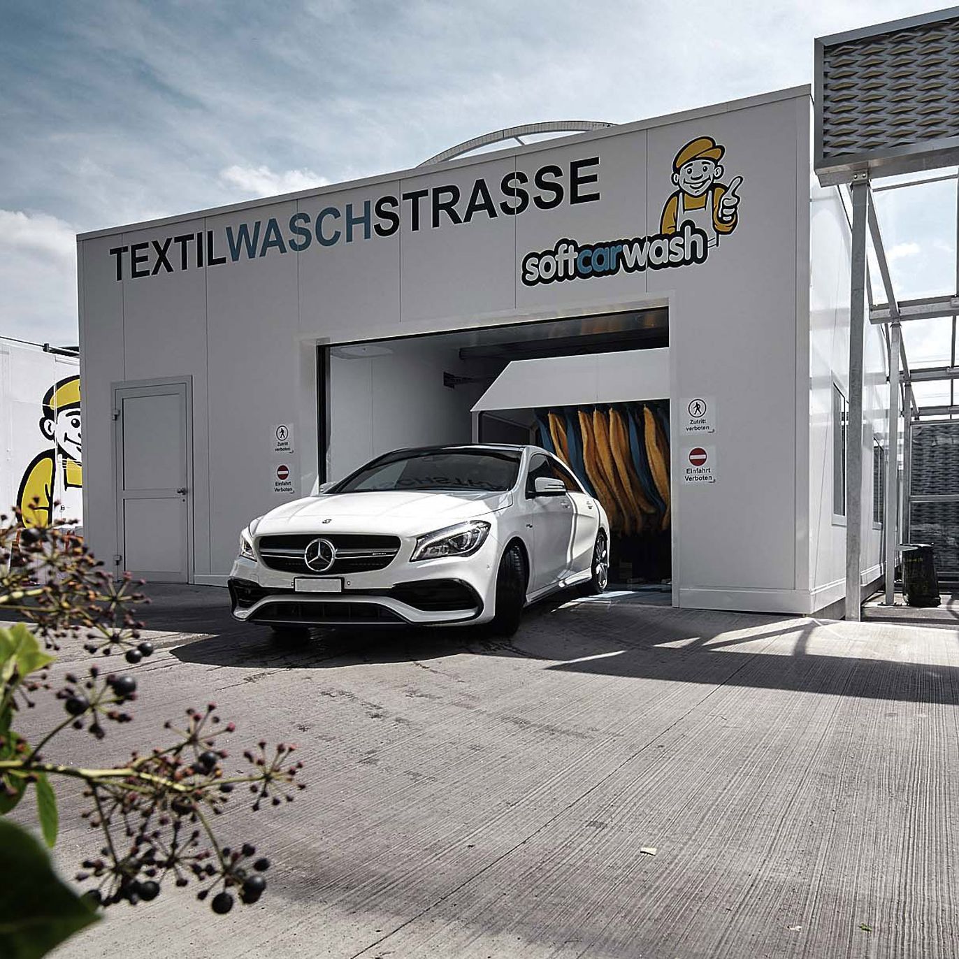 Ein sauber geputztes Auto fährt aus einer Waschstrasse von softcarwash